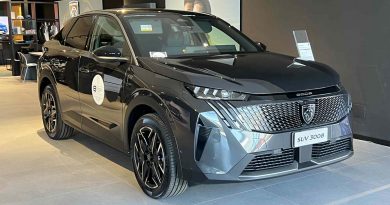 Nuova Peugeot 3008 Hybrid esposta in concessionaria, vista frontale e laterale sinistra, colore nero, con design SUV fastback e griglia anteriore distintiva.